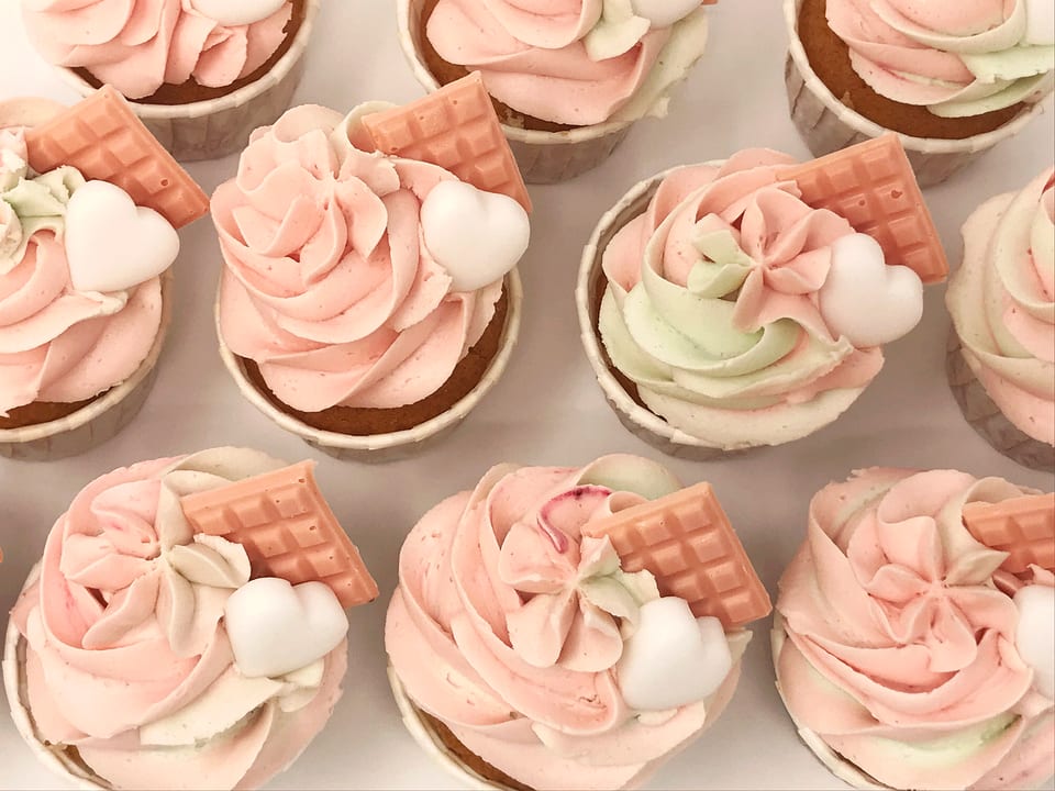 Cupcakes rosas decorados con nubes y chocolatinas