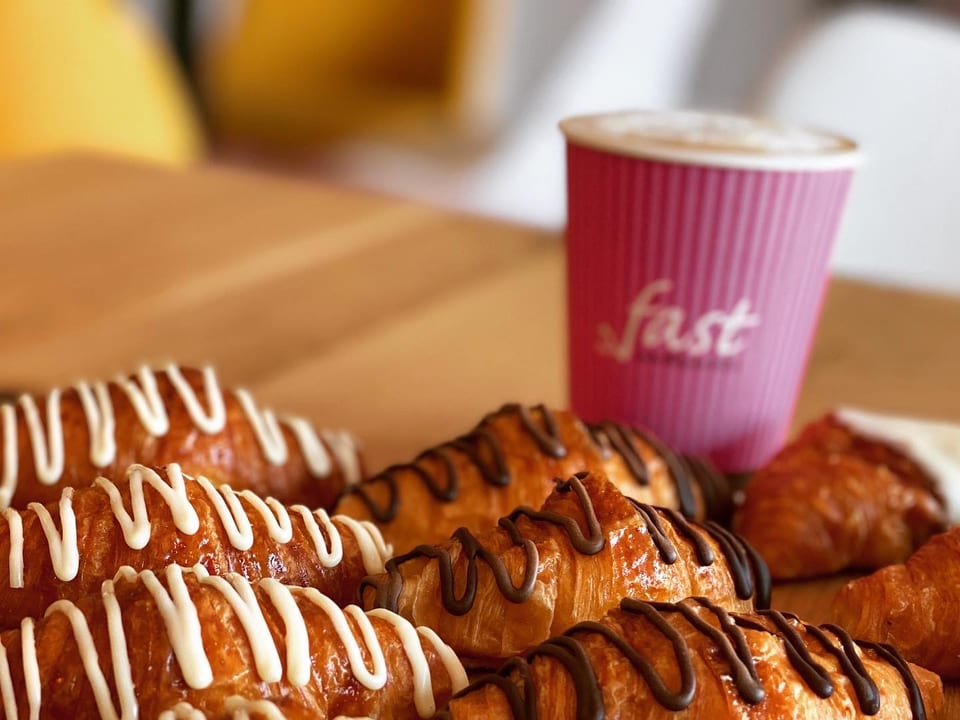Mini croissants de chocolate junto al vaso rosa de Fast