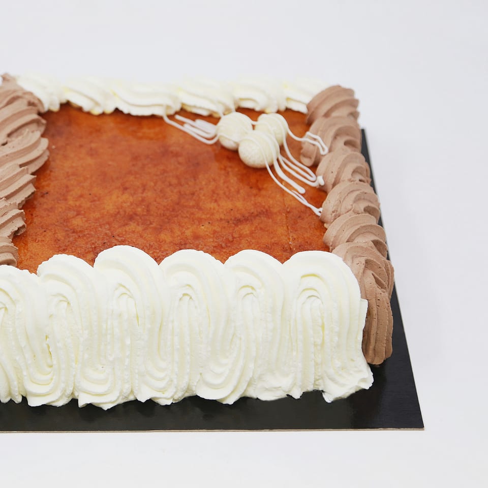 Tarta San Marcos cuadrada con yema tostada, nata y trufa